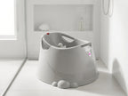 OKbaby Opla Badje in licht grijs in een douche met witte tegels